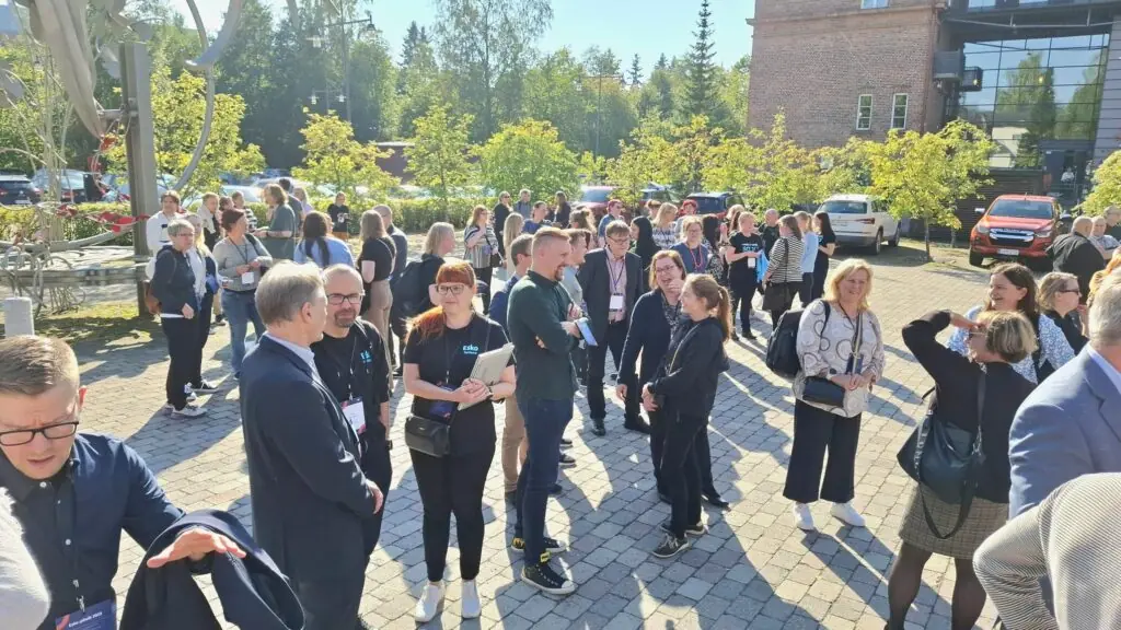 Esko-päivien vieraita aurinkoisella pihalla tauolla